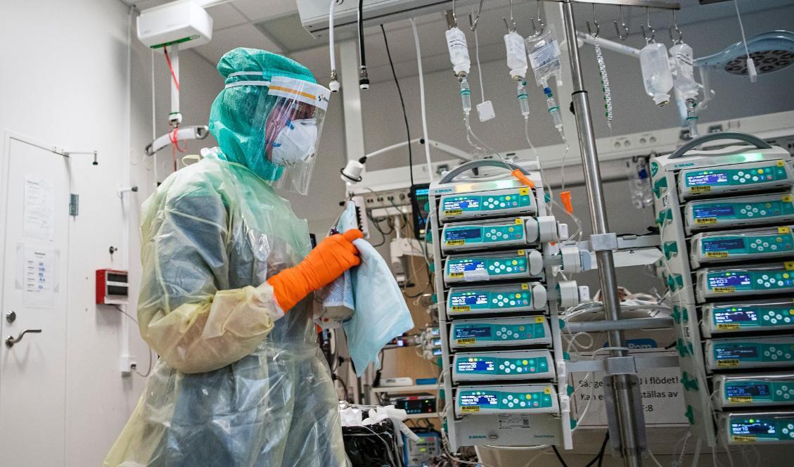 


En sjuksköterska, som bär skyddsutrustning och ansiktsmask, tar hand om en covid-19-patient i Karolinska sjukhuset i Solna den 19 april 2020. Foto: Jonathan Nackstrand/AFP via Getty Images                                                                                                                                                