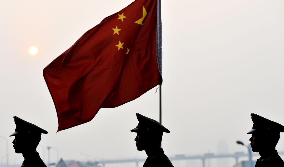 


Kinesiska militärer går förbi en kinesisk flagga i Shanghai den 21 oktober 2010. Foto: Philippe Lopez/AFP via Getty Images                                                                                                                                     