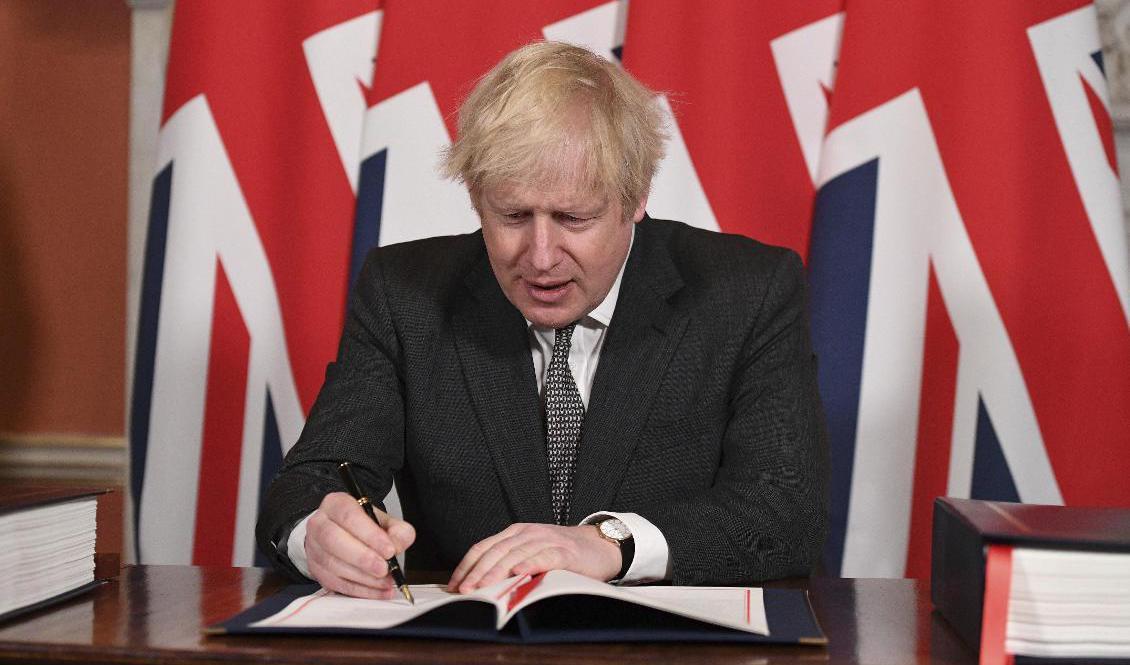 Storbritanniens premiärminister Boris Johnson undertecknar avtalet. Foto: Leon Neal/Pool via AP/TT