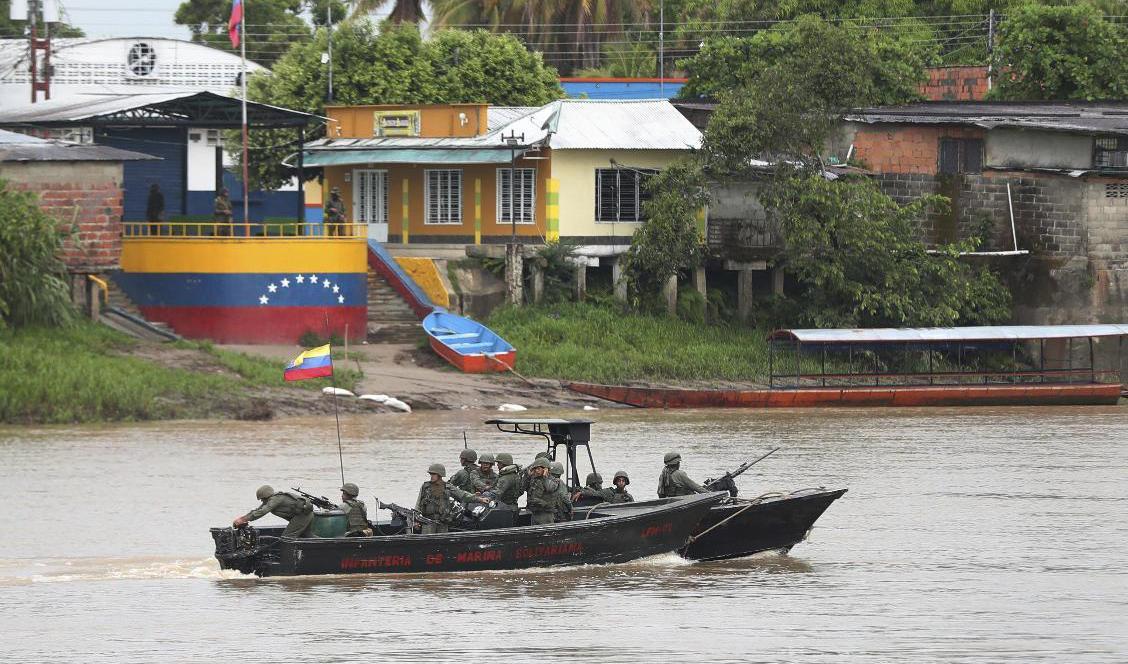 Soldater ur den venezuelanska flottan patrullerar längs gränsfloden Arauca, mellan Venezuela och Colombia. Bilden togs den 26 mars. Foto: Fernando Vergara/AP/TT