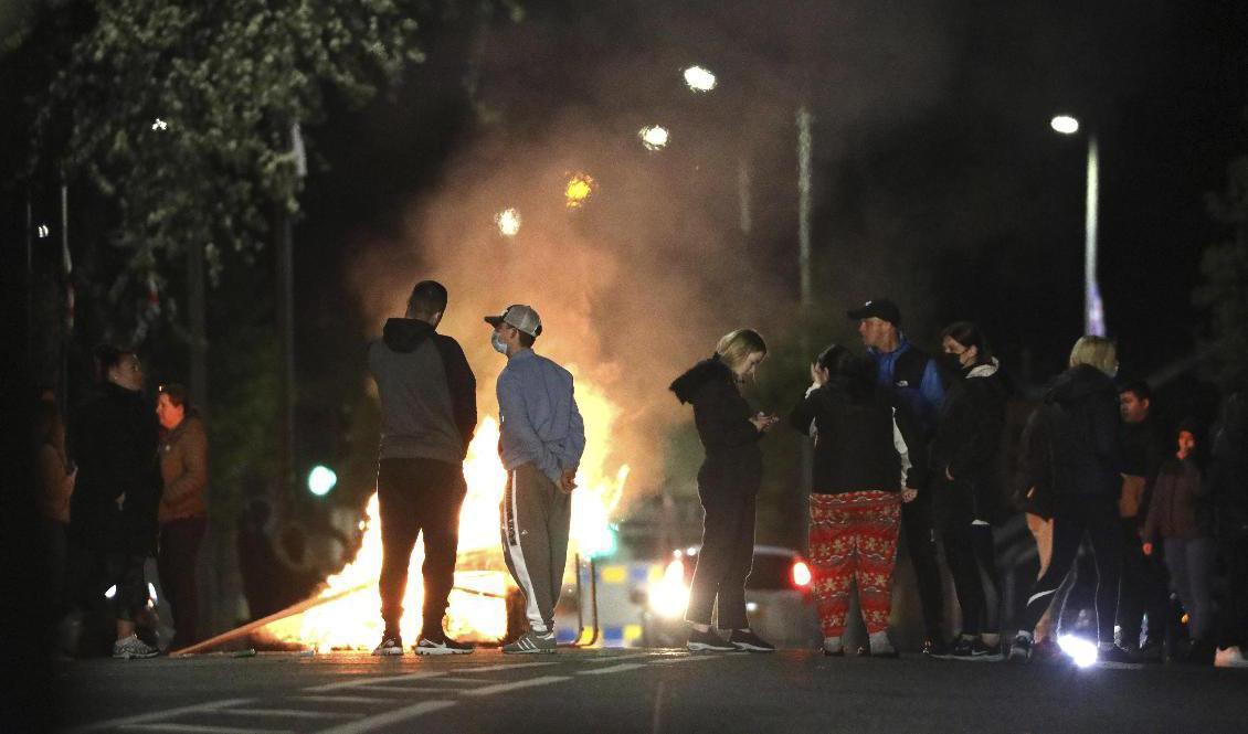 Lojalistiska ungdomar blockerade en väg i norra Belfast under fredagskvällen, som allt sammantaget blev lugnare än föregående kvällar. Foto: Peter Morrison/AP/TT