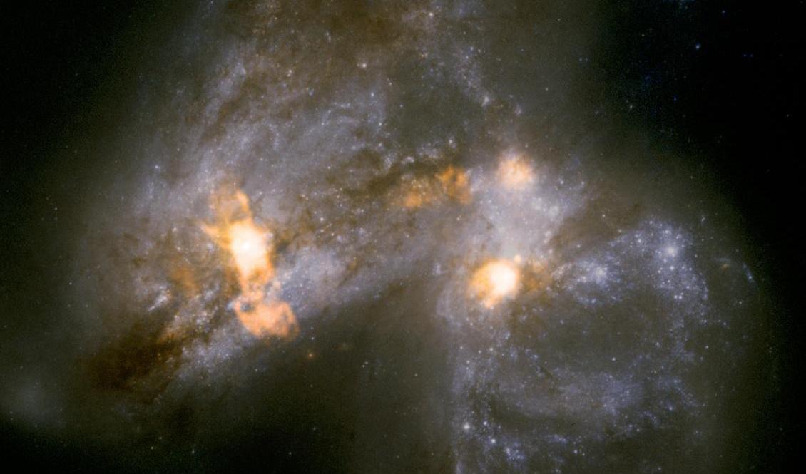 Galaxparet Arp 299 håller på att smälta samman. Lofar avslöjar hur vindar lika stora som en galax blåser ut från en jättelik stjärnfabrik som ligger dold bakom lager av stoft och damm i galaxernas ena kärna. Foto: Nasa/ESA/TT
