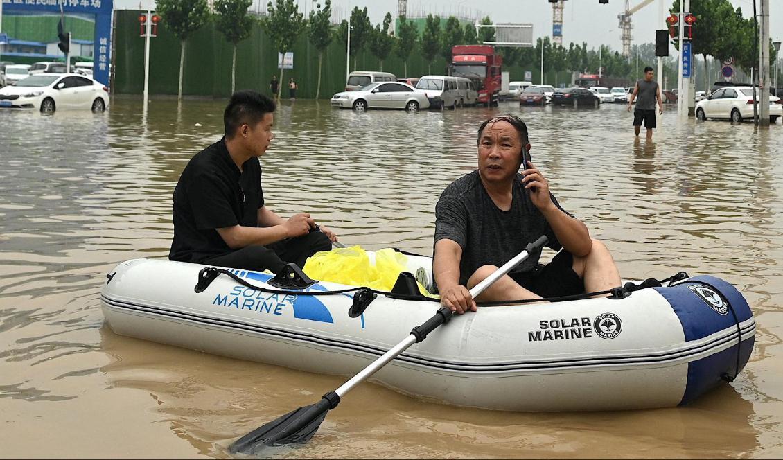 
Två män tar sig fram i en gummiflotte på de översvämmade gatorna i staden Zhengzhou. Förutom alla andra problem har förlusten av internet varit en stor fråga för invånarna. Foto: Noel Celis/AFP via Getty Images                                            