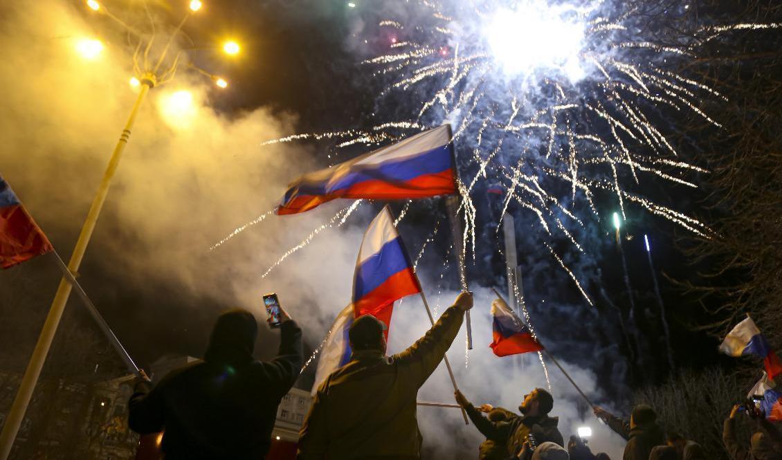 Människor viftar med ryska flaggor i centrala Donetsk för att fira att Ryssland förklarat utbrytarregionen som självständig. Foto: Alexei Alexandrov/AP/TT