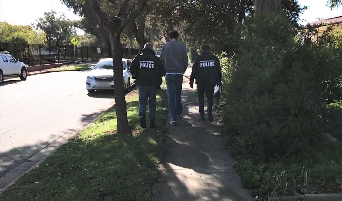 
Australiens federala polis AFP griper en man i en förort till Ingle Farm i Adelaide i Australien. Flera hundra personer runt om i världen har gripits i en global insats. Foto: Australian Federal Police (AFP).                                            