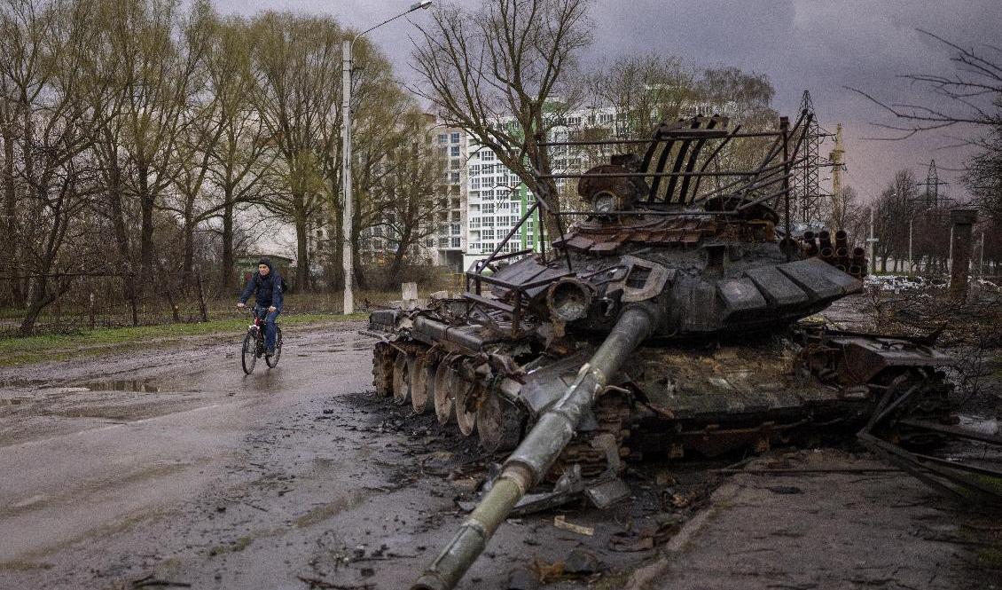 Man cyklar bredvid förstörd rysk stridsvagn i ukrainska staden Tjernihiv, torsdag 21 april. Foto: Emilio Morenatti/AP/TT