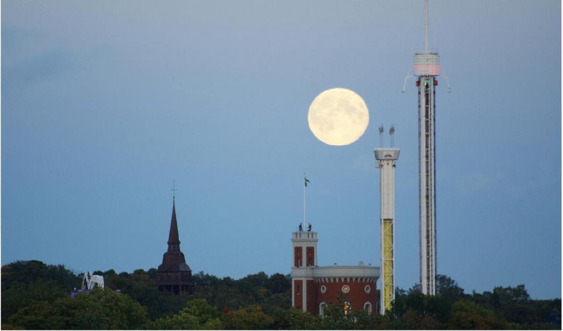 

Gammalt möter nytt, den uråldriga månen visar tiden. Seglora kyrka på Skansen, samt Kastellholmen och Gröna lund. Foto: Emil Almberg                                                                                        