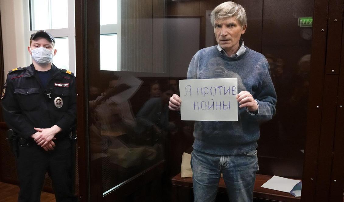 Aleksej Gorinov vid en tidigare rättegång i samma ärende. På skylten står det "Jag är emot kriget". Arkivbild. Foto: Alexander Zemlianichenko/AP/TT
