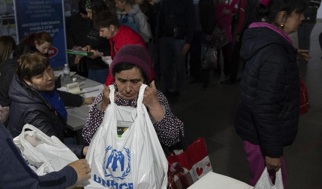 En kvinna får en påse från FN:s flyktingorgan UNHCR vid ett centrum i Zaporizjzja för människor som tvingats bort från sina hem på grund av kriget. Bilden togs i början av maj. Foto: Evgeniy Maloletka/AP/TT