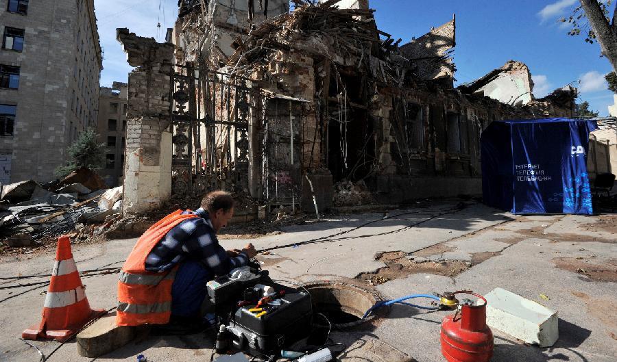 

En kommunalarbetare reparerar skadade tekniska installationer efter en beskjutning i centrala Charkiv den 18 september. Foto: Sergei Chuzavkov/AFP via Getty Images                                            