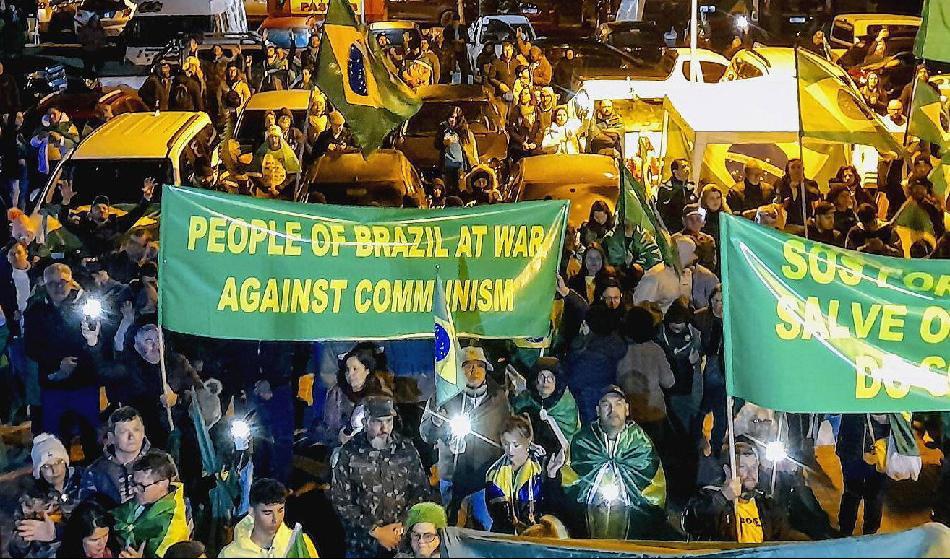 Demonstranter med banderoll på engelska med texten ”Brasiliens folk i krig mot kommunismen” i staden Curitiba, Brasilien, den 4 november 2022. Foto: Frederico Vidovix