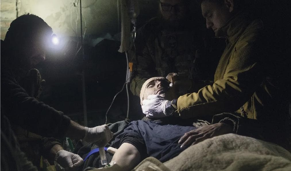 Sjukvårdare hjälper en skadad ukrainsk soldat utanför Bachmut i Donetsk-regionen i Ukraina, där hårda strider rasat den senaste tiden. Foto: Chris McGrath/Getty Images