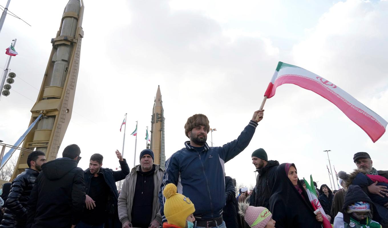 Mot en fond av ballistiska robotar samlades människor i centrala Teheran på lördagen för att fira den islamiska revolutionens 44:e årsdag. Foto: Vahid Salemi/AP/TT