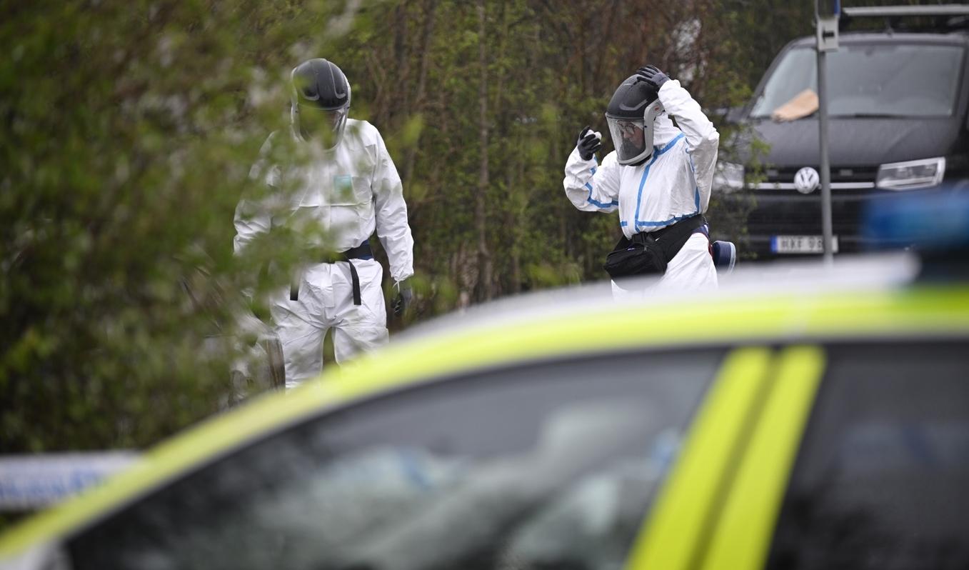 Polis och kriminaltekniker på plats vid en utbränd bil på en parkering i Lomma kommun på söndagen. I bilen hittas något som polisen misstänker är en människokropp. Foto: Johan Nilsson/TT