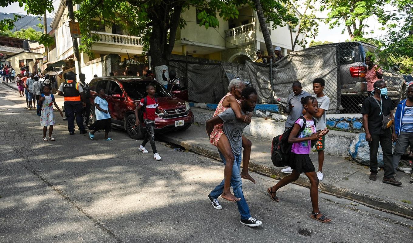 Människor lämnar ett område i Port-au-Prince den 24 april. Foto: Richard Pierrin/AFP via Getty Images