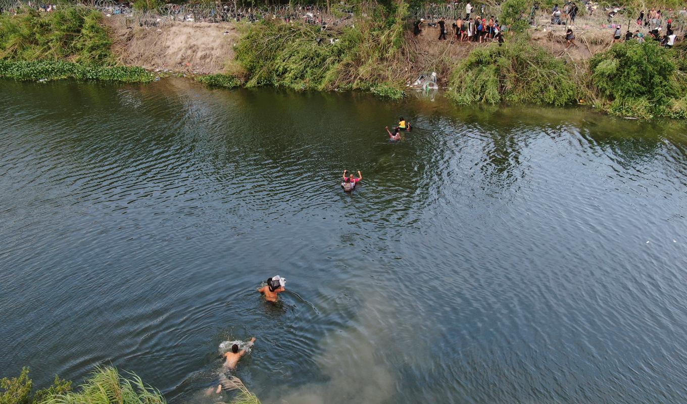 Migranter i färd med att ta sig från Matamoros i Mexiko över till den amerikanska sidan via floden Rio Grande. Foto: Fernando Llano/AP/TT