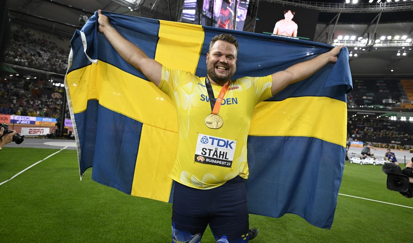 Sveriges Daniel Ståhl firar med guldmedalj och svenska flagga. Foto: Jessica Gow/TT