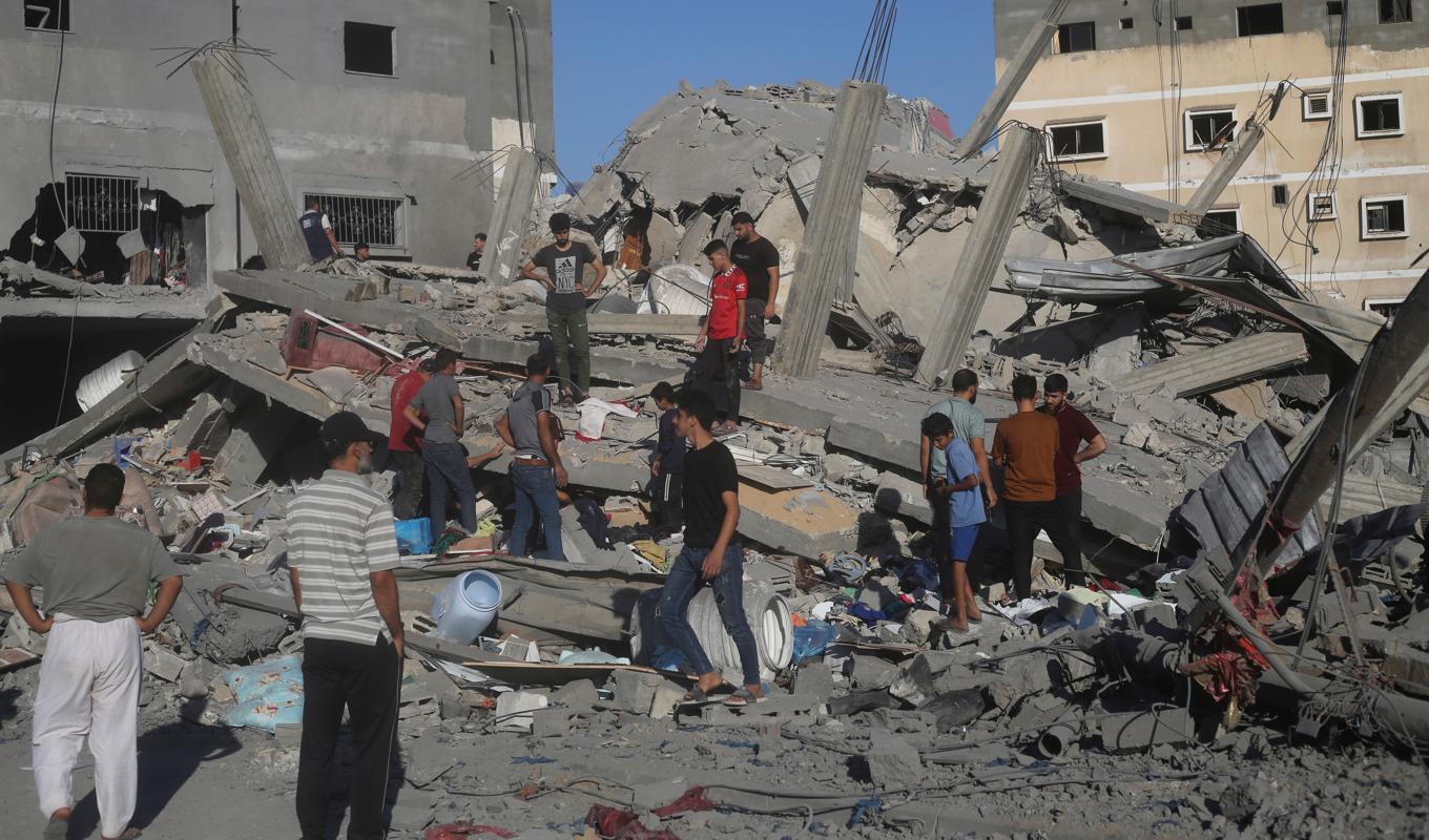 En byggnad som förstördes i Rafah i södra Gaza under natten till lördag. Palestinier letar efter överlevande. Foto: Hatem Ali/AP/TT