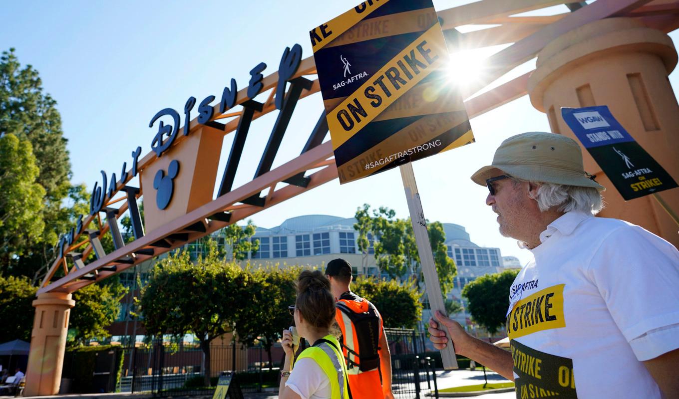 Strejkande fackmedlemmar utanför Walt Disney Studios i Burbank, Kalifornien. Strejken avbryts under torsdagen sedan ett preliminärt avtal har lagts fram. Arkivbild. Foto: Chris Pizzello/AP/TT