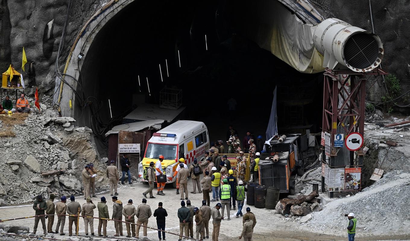 En ambulans och räddningsarbetare är samlade vid tunneln i Uttarkashi i Indien den 28 november 2023. Foto: Sajjad Hussain/AFP via Getty Images.