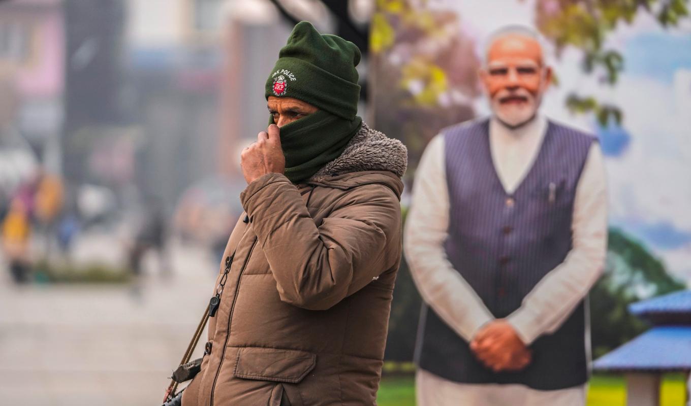 En polis, och bakom honom Narendra Modi i pappfigur, bevakar en marknad i Srinagar i den av Indien kontrollerade delen av Kashmir på måndagen. Foto: Mukhtar Khan/AP/TT