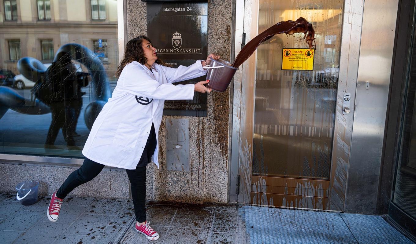 ”Scientist Rebellion” häller en mörk vätska på regeringskansliet för att uppmana regeringen att upphöra med sitt stöd till fossila bränslen, den 12 maj 2023. Foto: Jonathan Nackstrand/AFP via Getty Images