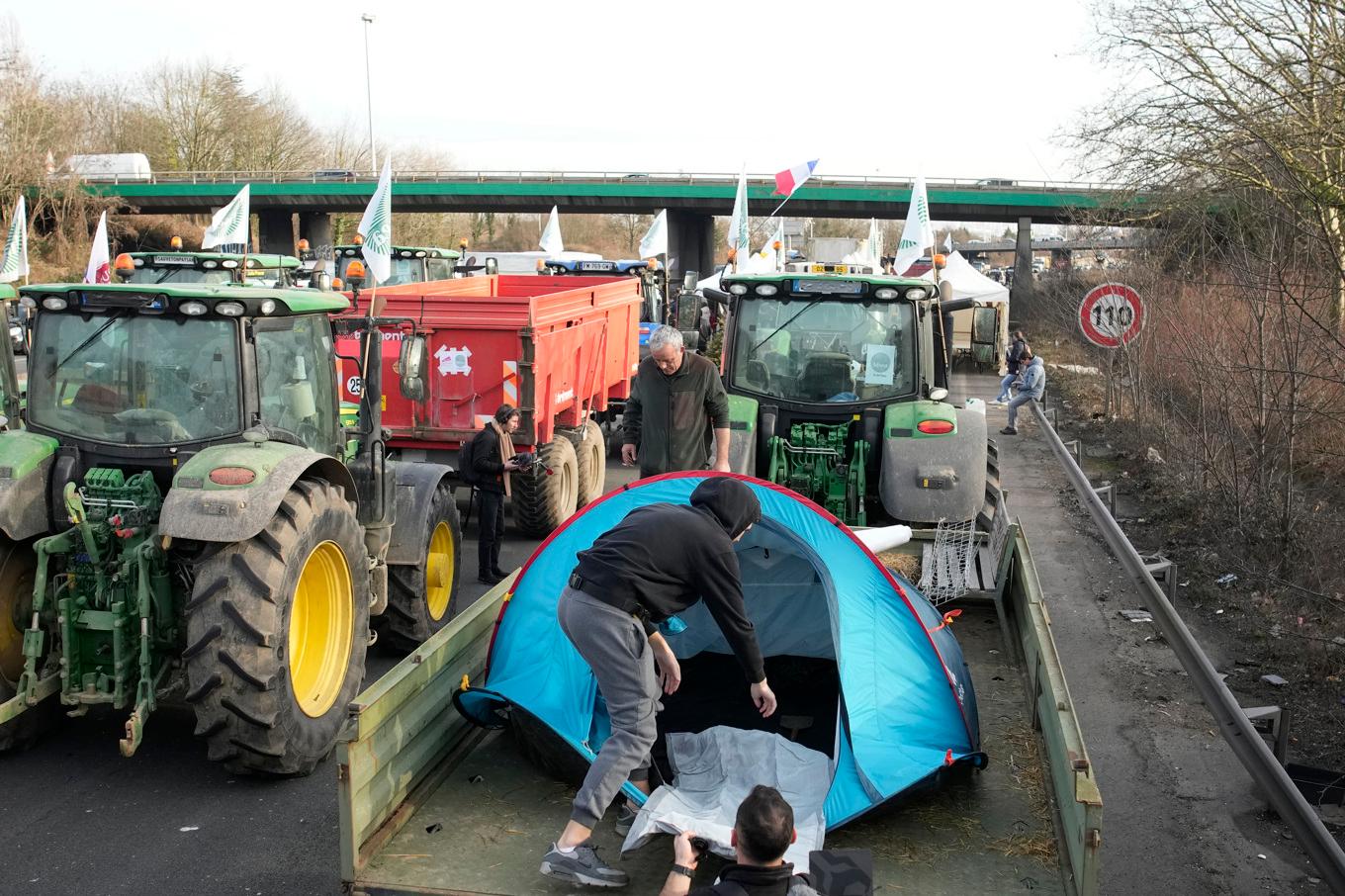 Hundratals traktorer blockerar ett antal av de stora infartslederna till Paris. Foto: Christophe Ena/AP/TT