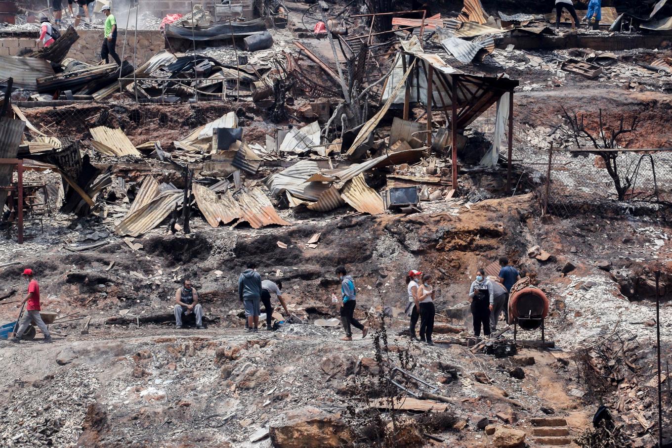 Röjning pågår efter skogsbränder som nått och ödelagt samhället Viña del Mar i Chile. Foto: Cristobal Basaure/AP/TT