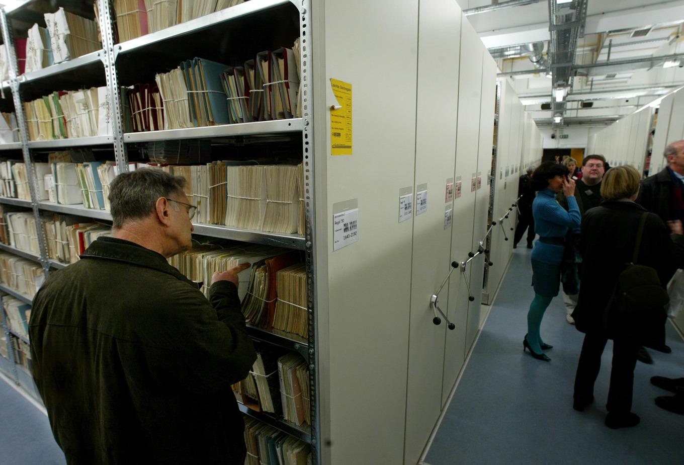 Besökare på museet i det tidigare Stasi-högkvarteret i Berlin granskar hyllor med dokument lördagen den 15 januari 2005. Foto: Jan Bauer/AP/TT