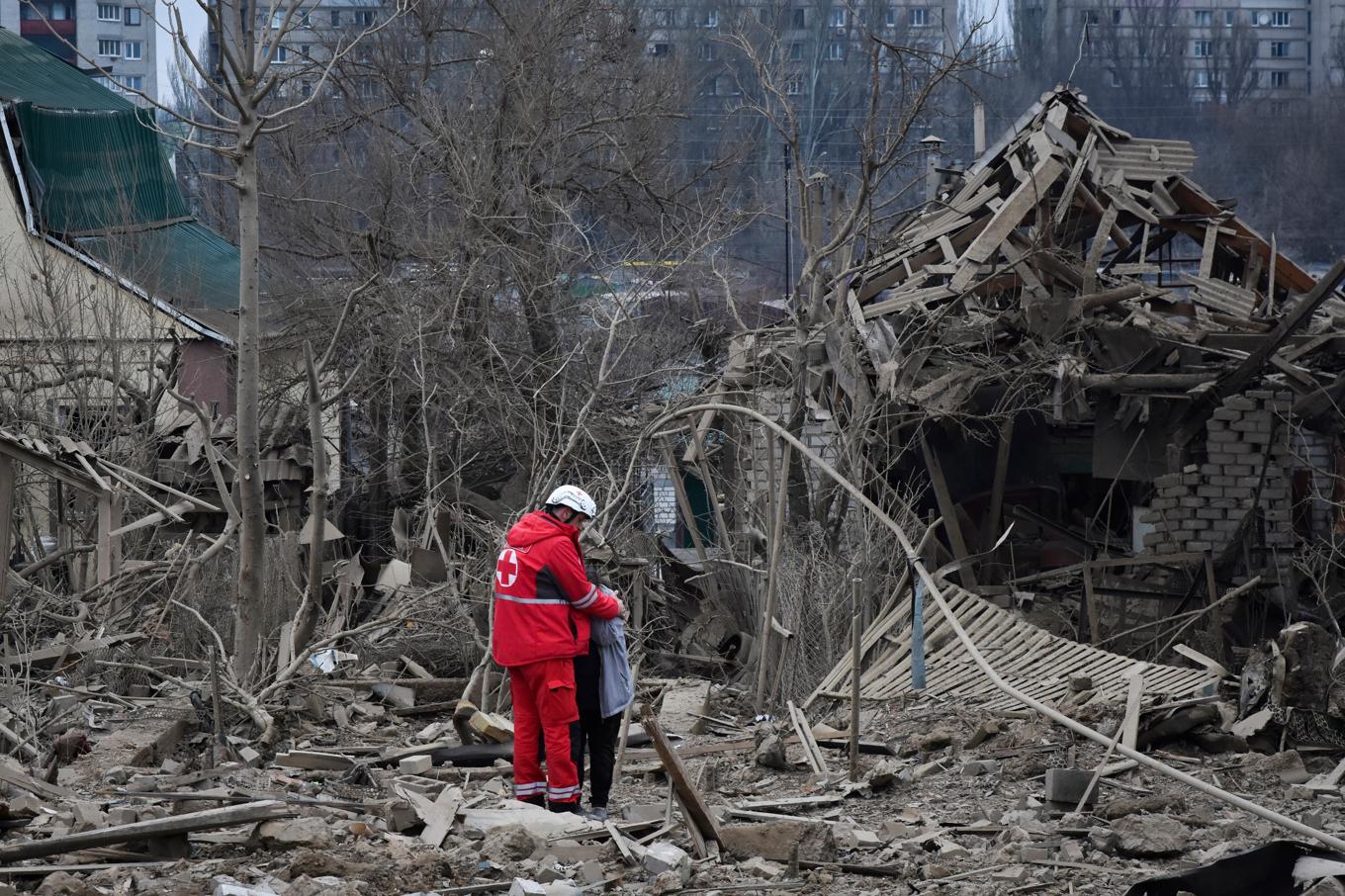 En sjukvårdare kramar om en gråtande kvinna i ett bostadsområde i Zaporizjzja, efter nattens ryska anfall. Foto: Andriy Andriyenko/AP/TT