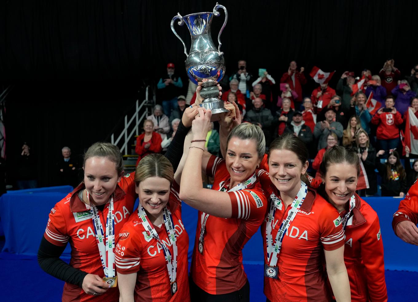 Kanadas lag Rachel Homan lyfter bucklan efter finalvinsten mot Schweiz. Foto: Frank Gunn/AP/TT