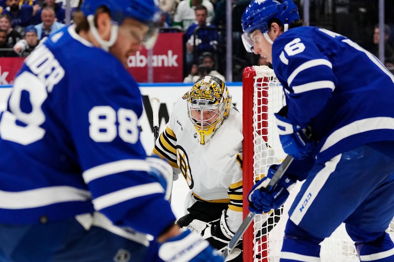 Bostons målvakt Jeremy Swayman vaktar kassen med Torontos William Nylander och Mitch Marner jagandes efter pucken. Foto: Frank Gunn/The Canadian Press via AP/TT