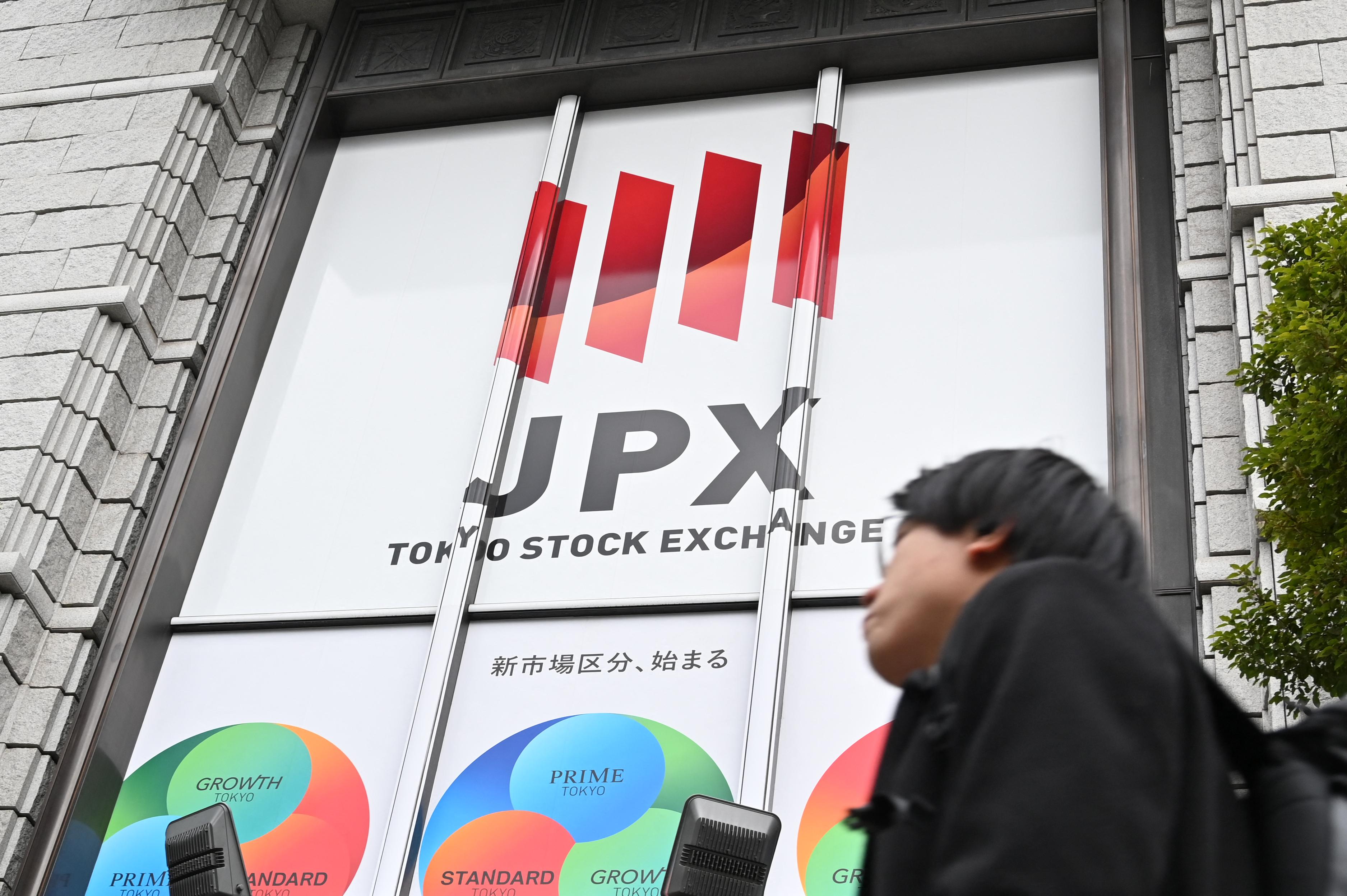 En man går förbi Tokyo-börsen i Tokyo i Japan den 19 mars. Foto: Kazuhiro Nogi/AFP via Getty Images