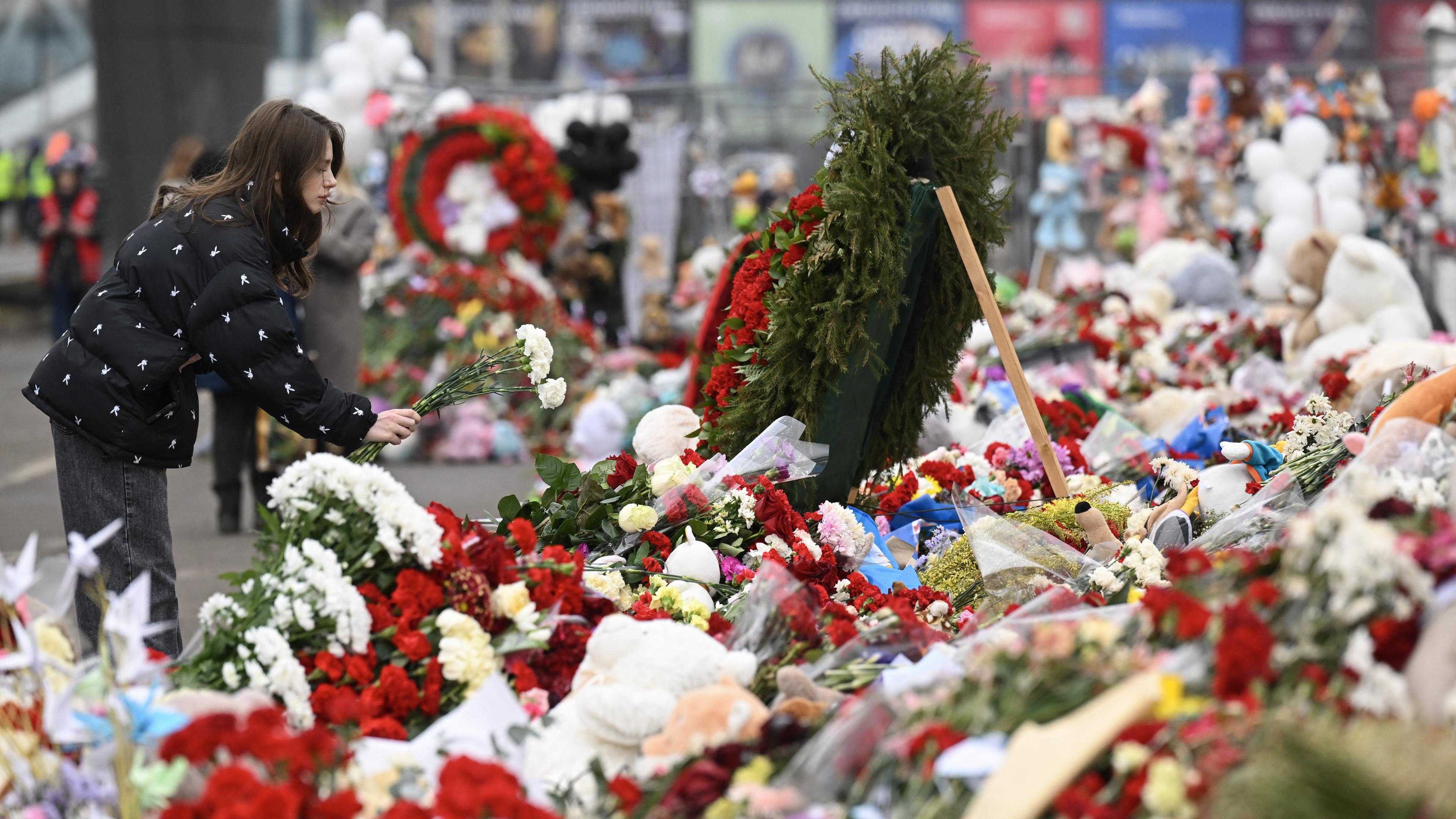 En kvinna lägger ner blommor vid Crocus City Hall i Moskvas norra förort Krasnogorsk den 29 mars, en vecka efter den dödliga terrorattacken där. Foto: Natalia Kolesnikova/AFP via Getty Images