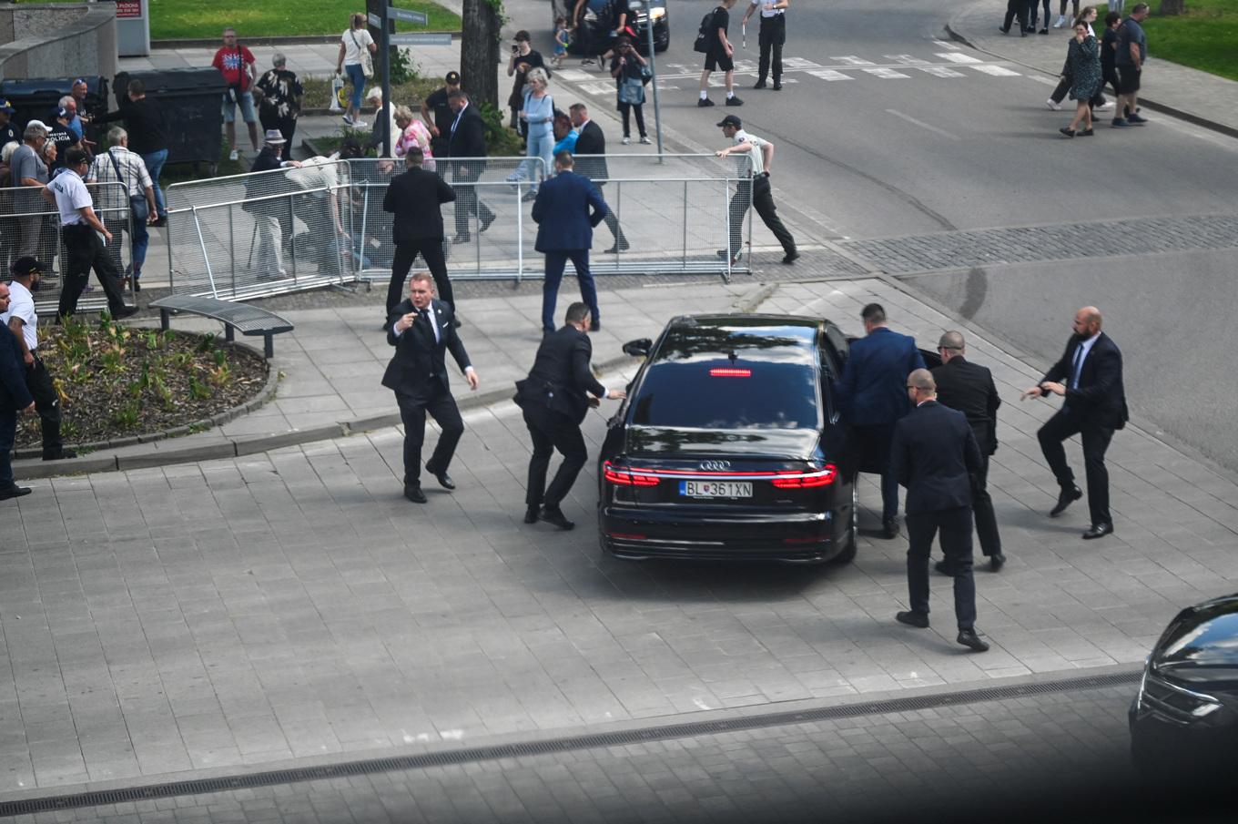 Säkerhetspersonal hjälper in Robert Fico i en bil efter att han skjutits. i staden Handlova. Foto: Radovan Stoklasa/Reuters/TT