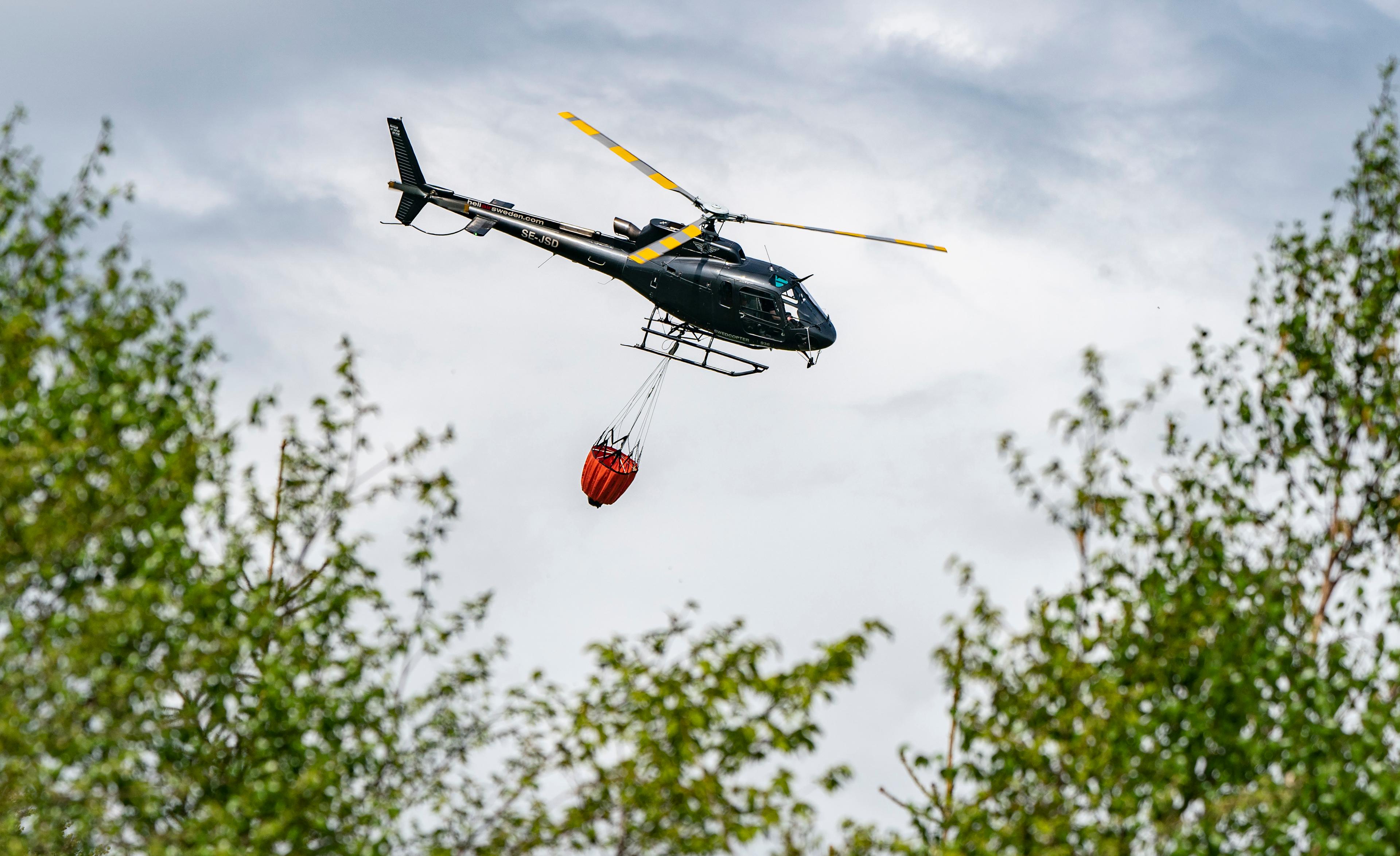 Två helikoptrar jobbar med branden norr om Gnarp. Arkivbild. Foto: Johan Nilsson/TT