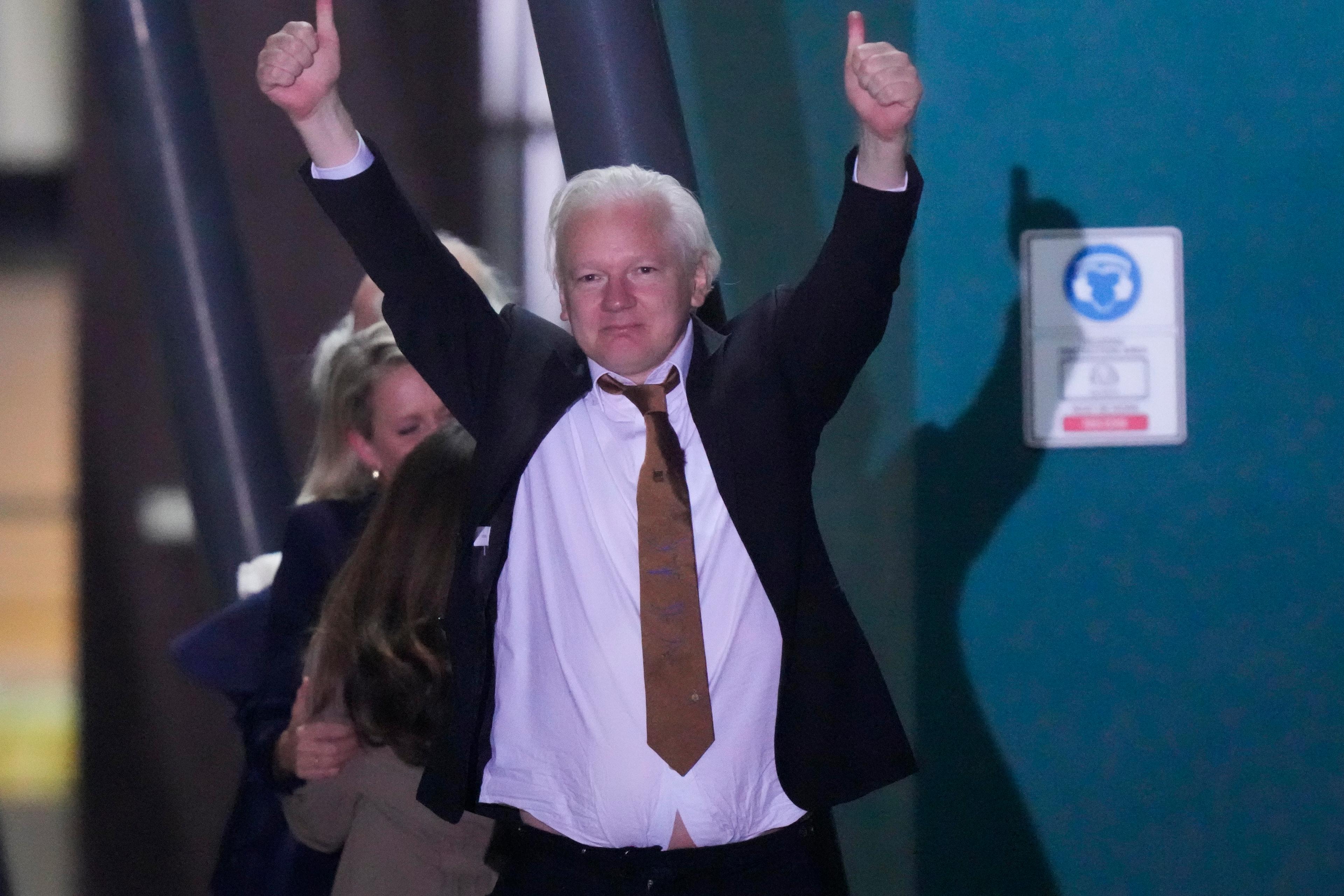 Julian Assange gör dubbel tumme upp efter att ha klivit av flygplanet i hemlandet Australien. Foto: Rick Rycroft/AP/TT