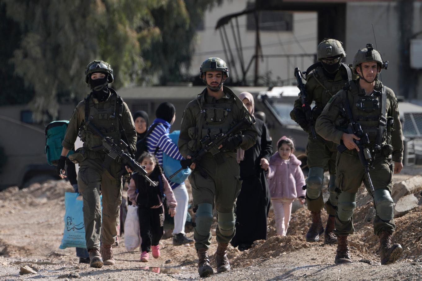 Israeliska soldater går framför palestinier som flyr offensiven i Jenin på torsdagen. Foto: Majdi Mohammed/AP/TT