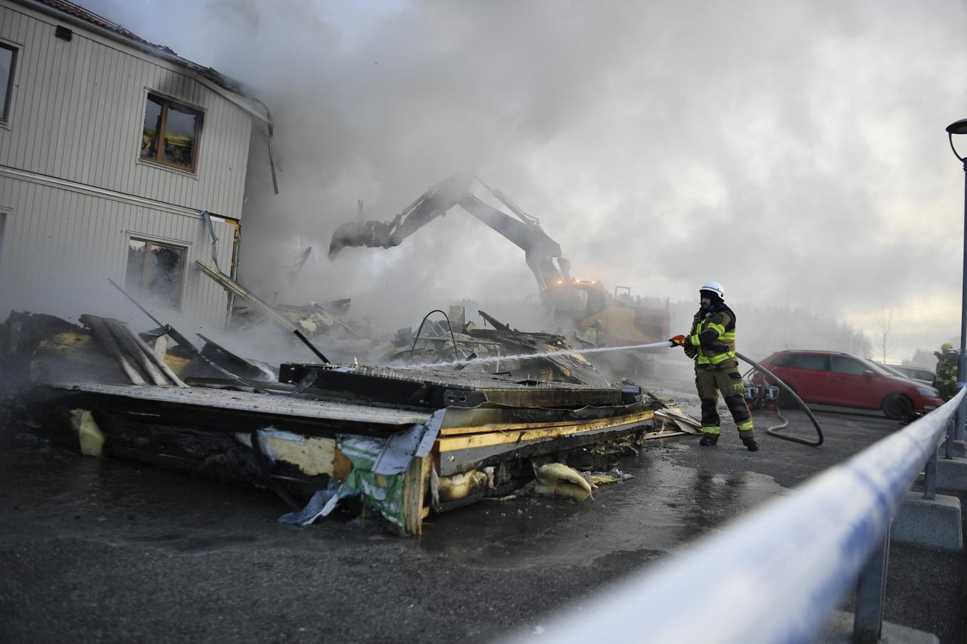 Räddningstjänsten har rivit ena hörnet på fastigheten med hjälp av grävskopa. Foto: Oscar Olsson/TT