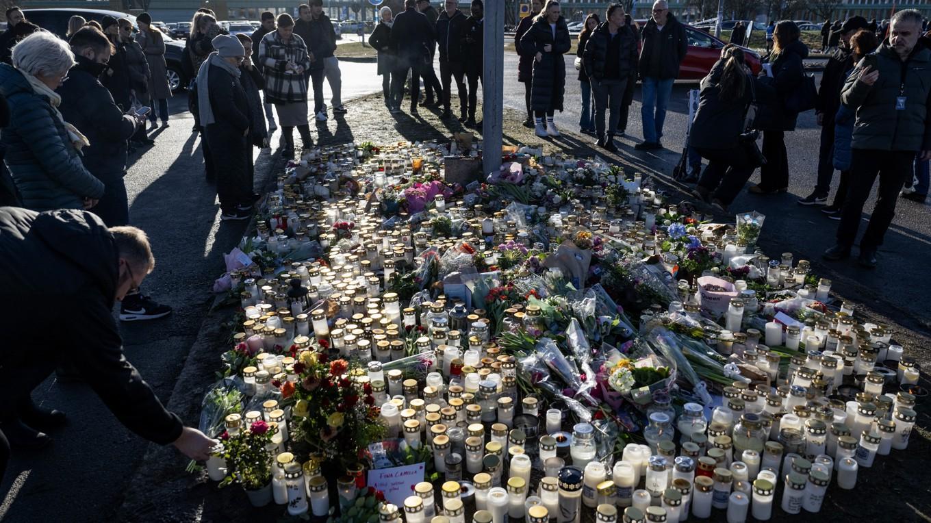 Sörjande lämnar blommor och ljus vid minnesplatsen utanför skolan efter skolskjutningen i Risbergska skolan. Foto: Christine Olsson/TT