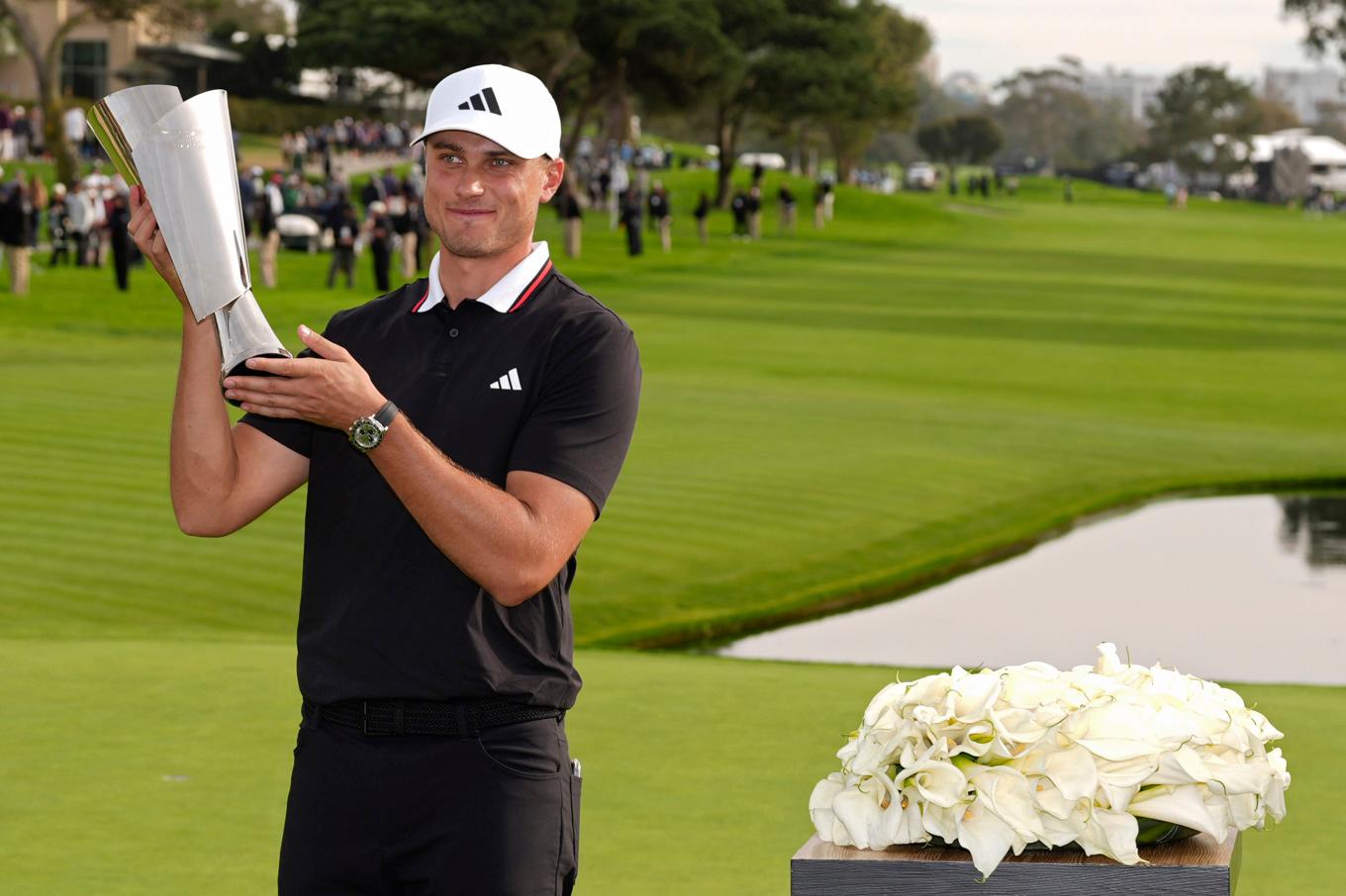 Ludvig Åberg med bucklan efter segern i stortävlingen på PGA-touren under söndagseftermiddagen. Sedan väntade simulatorgolf i inomhusligan TGL. Foto: Gregory Bull/AP/TT