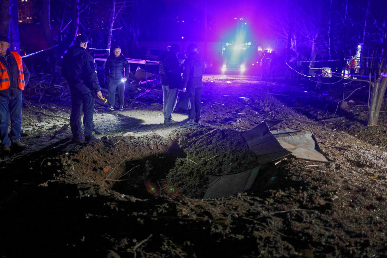 En krater i ett bostadsområde i Charkiv efter attackerna under natten till söndag. Foto: Yevhen Titov/AP/TT