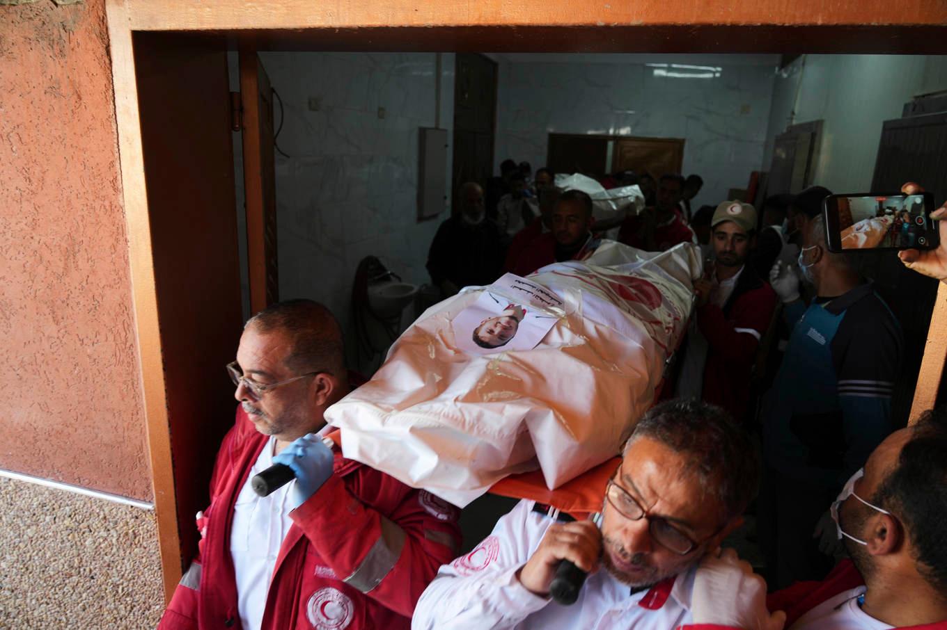 Sörjande bär en av dem som dödades i en israelisk attack mot räddningspersonal i Gaza. Foto: Abdel Kareem Hana/AP/TT