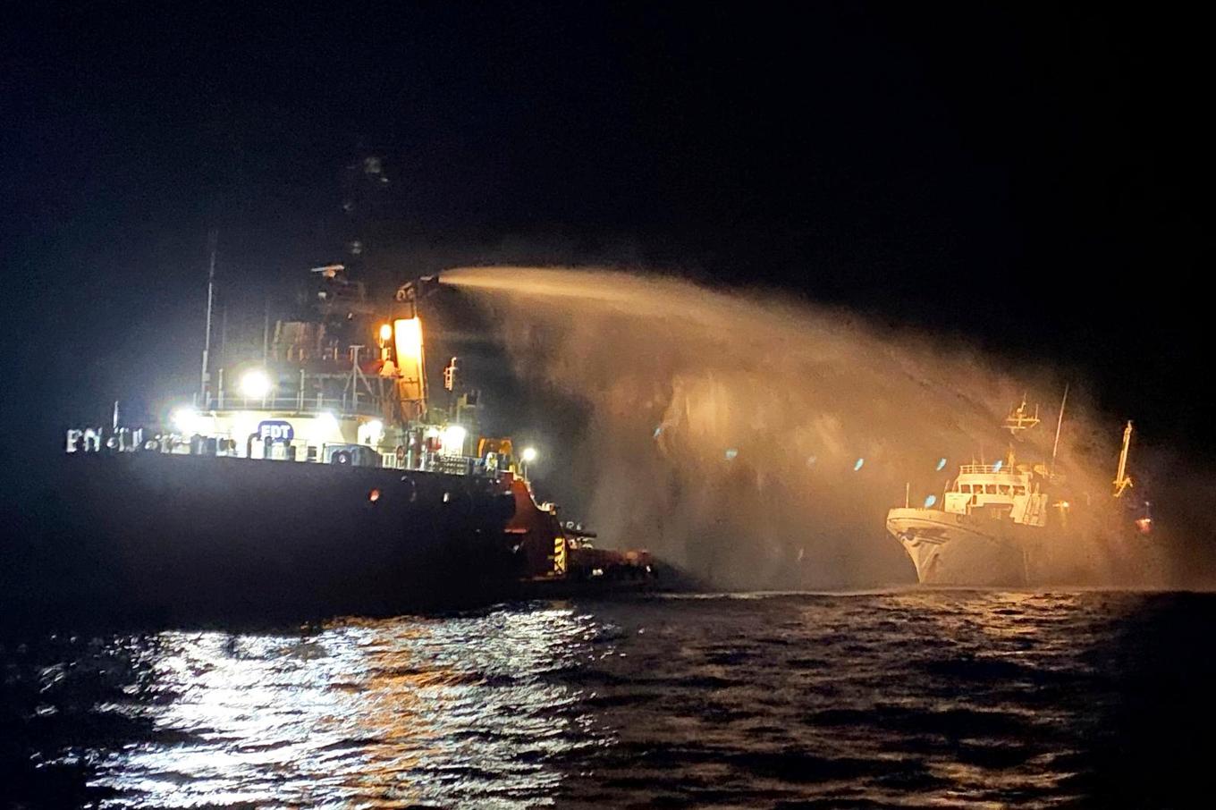 En bogserbåt med brandbekämpningsutrustning kom Conscience till undsättning. I fartygets främre skrov syns ett hål. Foto: Malta Vessel Traffic Services via AP/TT