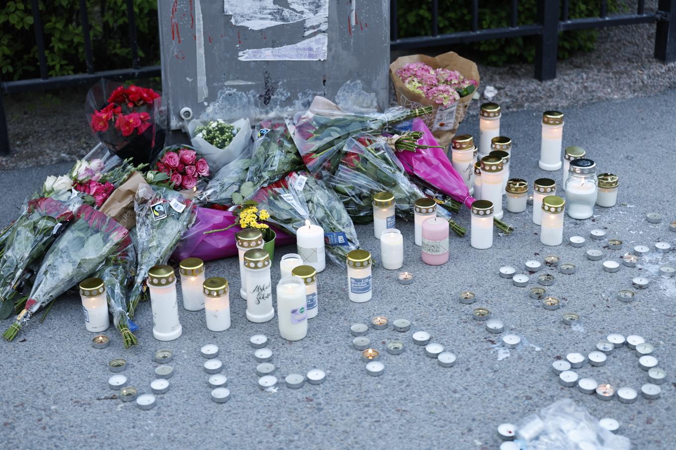 En minnesplats där människor lämnat blommor och ljus efter morden. Foto: Fredrik Persson/TT