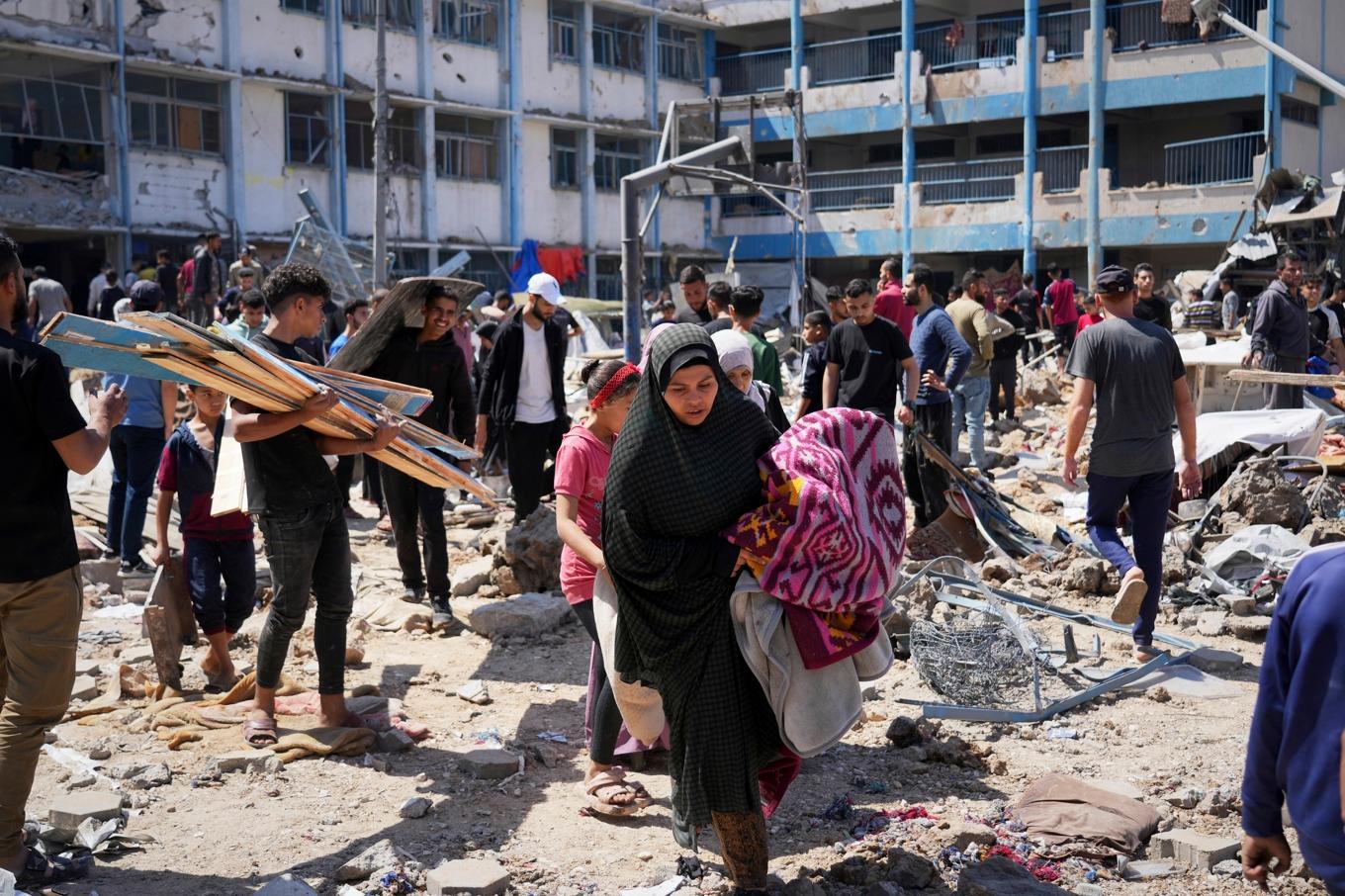 Palestinier hämtar på onsdagen tillhörigheter efter en attack mot en skola som använts som härbärge för människor på flykt i Bureij i centrala Gaza. Foto: Abdel Kareem Hana/AP/TT