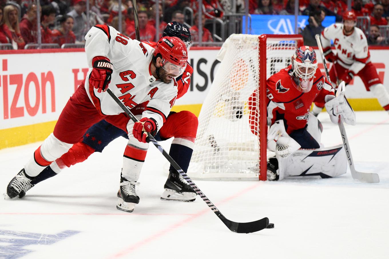 Carolinas Jordan Martinook siktar på ett skott mot Washington, med Logan Thompson i mål. Foto: Nick Wass/AP/TT