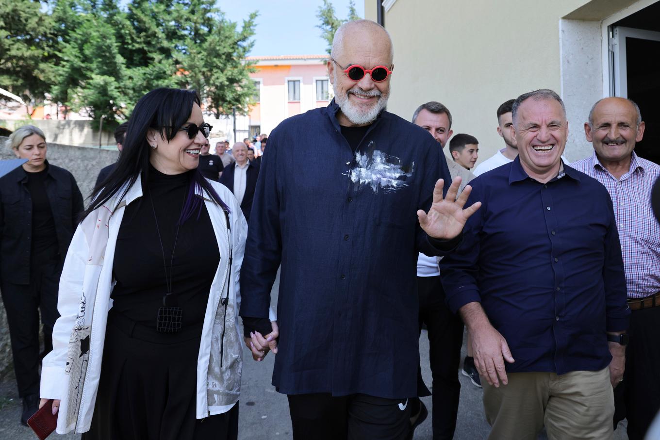 Albaniens sittande premiärminister Edi Rama (mitten) lämnar en vallokal tillsammans med sin fru på söndagen. Foto: Vlasov Sulaj/AP/TT