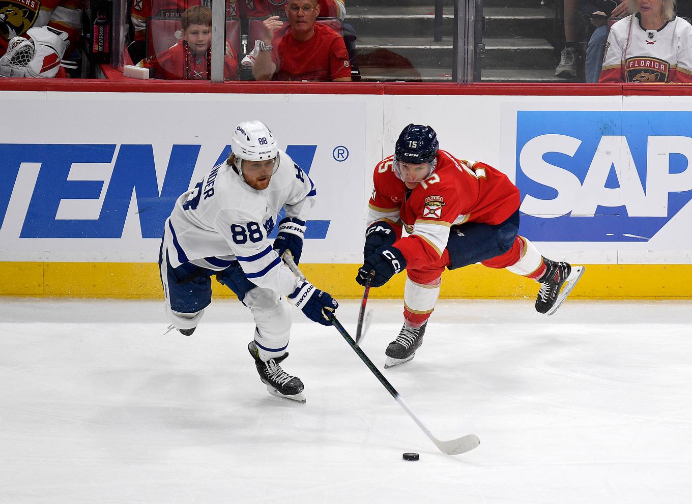 Torontos William Nylander (88) kämpar om pucken med Floridas finländare Anton Lundell. Foto: Michael Laughlin/AP/TT