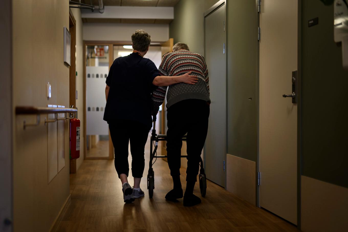 En person går med rullator med ett vårdbiträde bredvid på ett omsorgsboende för äldre. Arkivbild. Foto: Oscar Olsson/TT